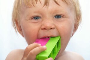 toddler chewing on block