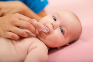 other using finger to massage baby's gums